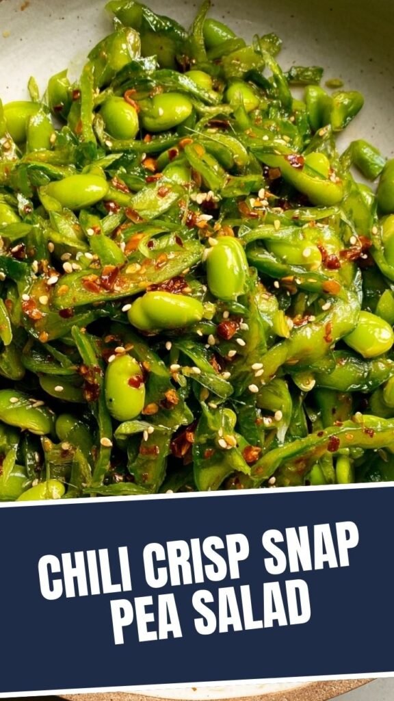 A fresh chili crisp snap pea salad in a white bowl with metal serving tongs.