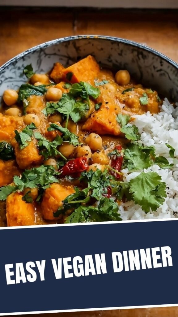 A vibrant bowl of sweet potato and chickpea curry garnished with fresh cilantro