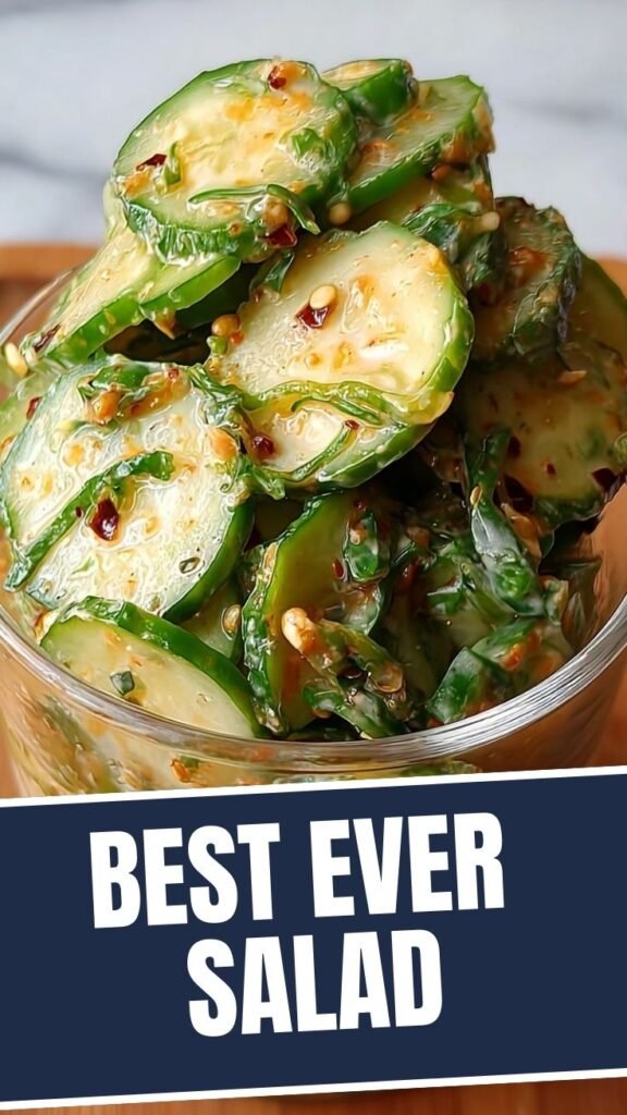 A fresh Asian cucumber salad with chili flakes and sesame seeds in a clear bowl