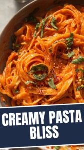 A close-up of a bowl of red pepper pasta, vibrant and appetizing.