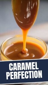 A spoonful of rich, golden-brown caramel sauce dripping from a silver spoon.