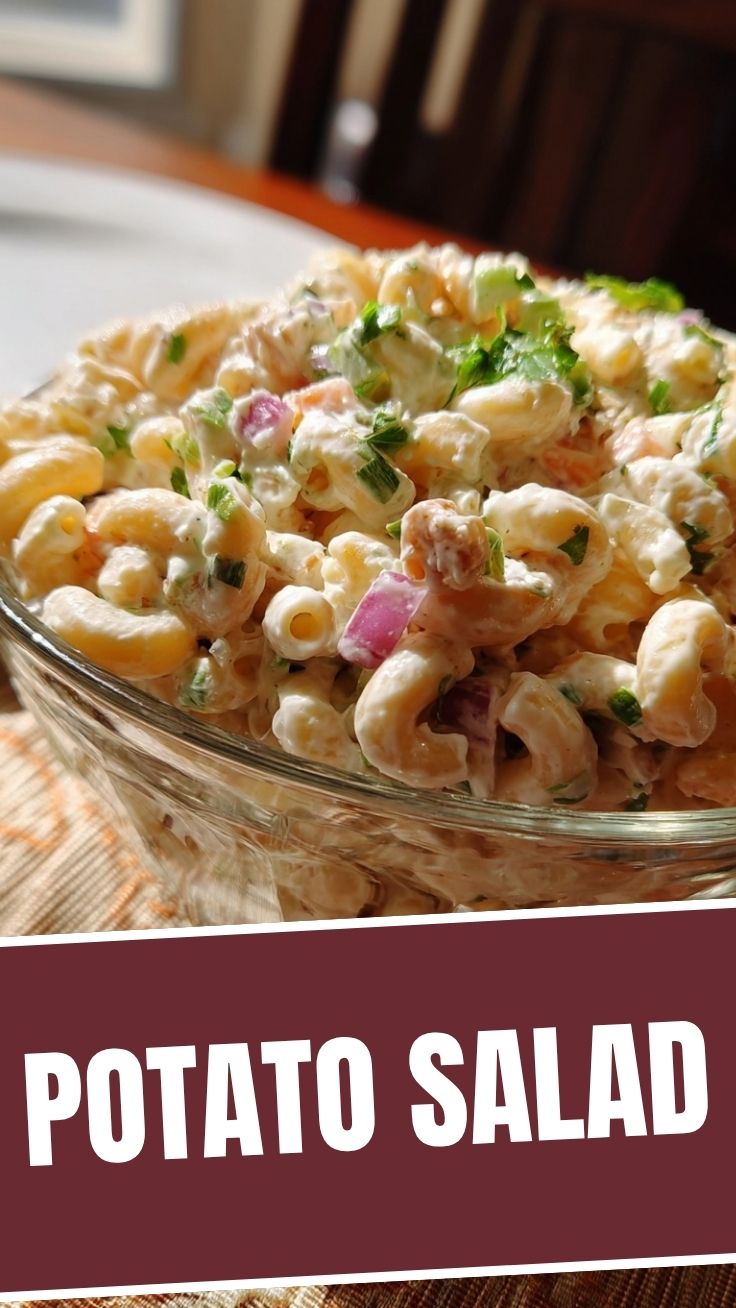 A bowl of creamy macaroni salad with vibrant vegetables.