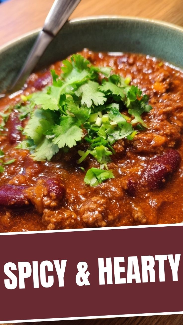 A bowl of hearty chili con carne garnished with fresh cilantro