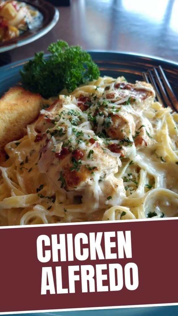 A serving of rich chicken alfredo pasta with grilled chicken slices and parmesan cheese.