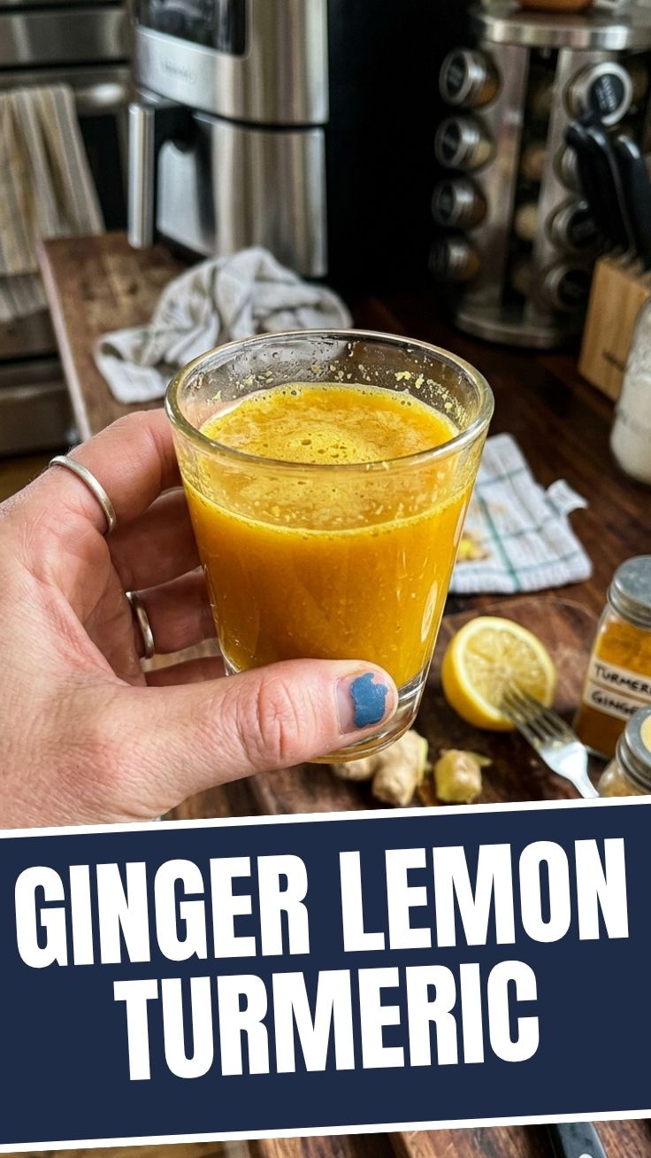 Close-up of a small glass bottle filled with a bright yellow ginger lemon turmeric shot