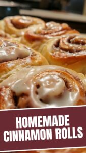 A plate stacked with warm, homemade cinnamon rolls drizzled with white icing.
