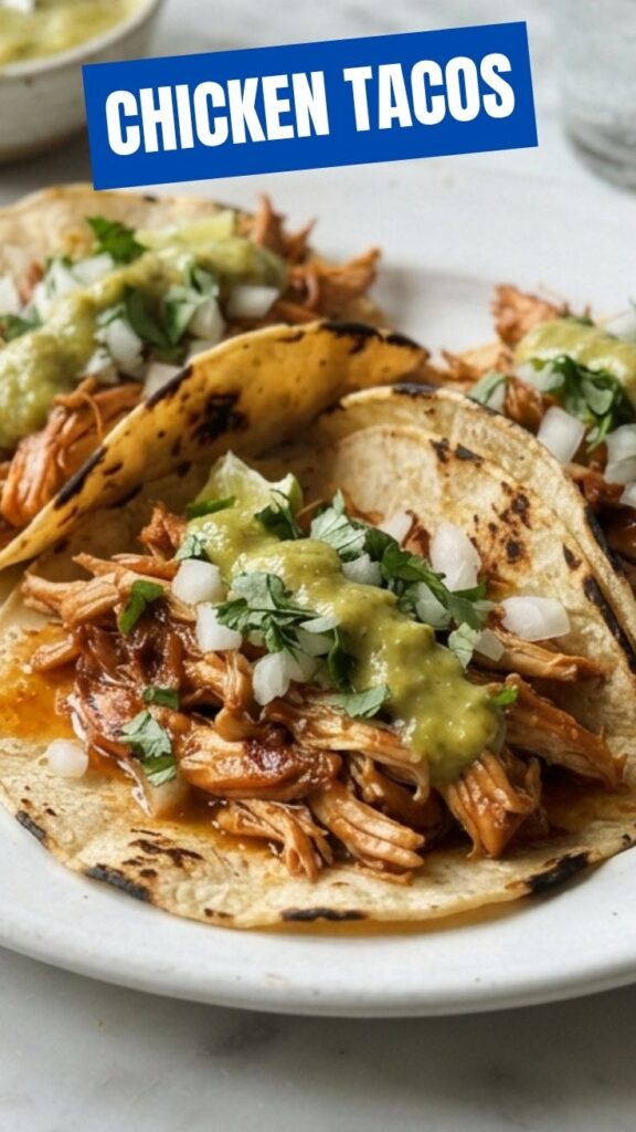 A close-up shot of two delicious chicken tacos with fresh toppings.