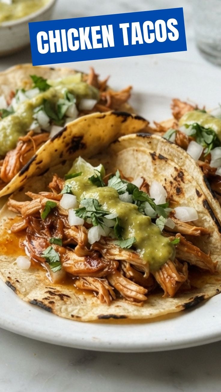 A close-up shot of two delicious chicken tacos with fresh toppings.